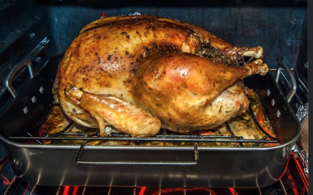 a turkey roasting in the oven for Thanksgiving dinner